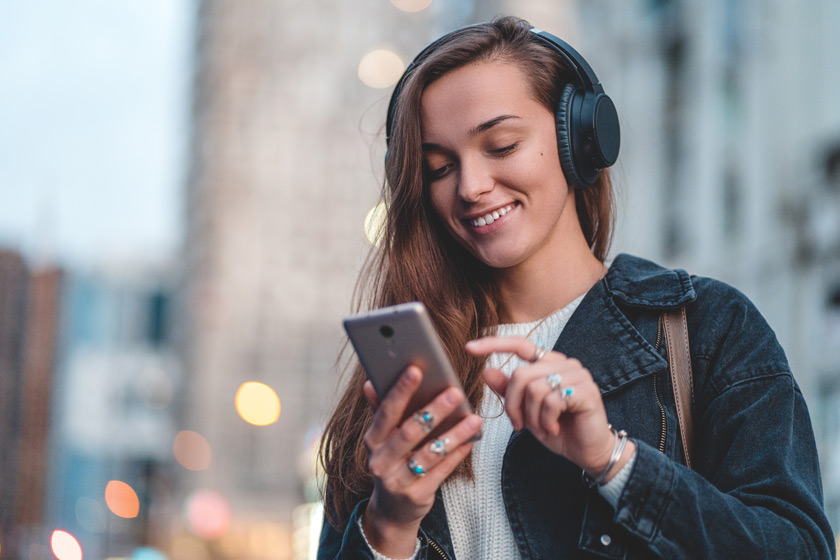 Junge Frau mit Smartphone und Headset